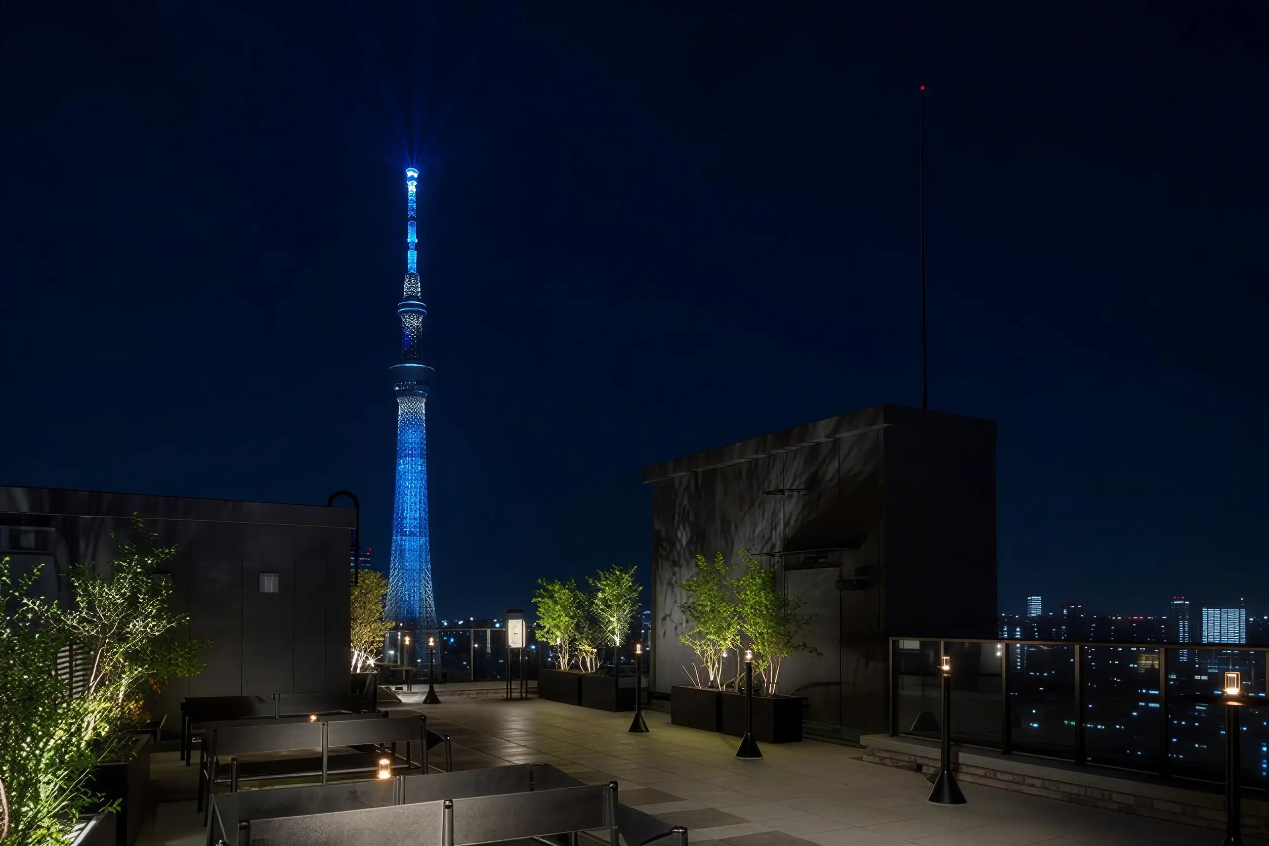 星野 OMO3 淺草 13 樓頂樓空中露台，入夜後無遮蔽直視點燈的東京晴空塔與下町街景