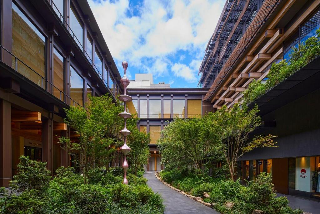 由建築大師隈研吾操刀設計的京都 Ace Hotel 外觀與新風館中庭，標誌性的木造格柵結合綠意庭園